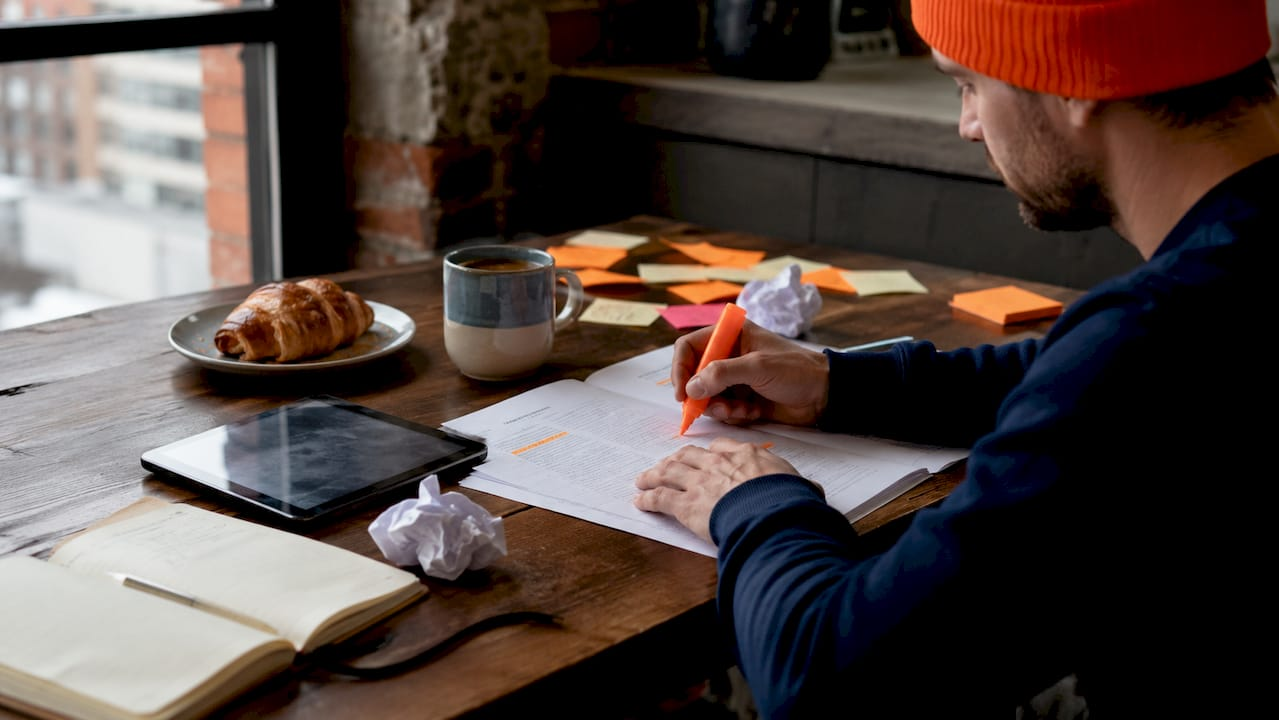 Hands writing creative brief for social ads